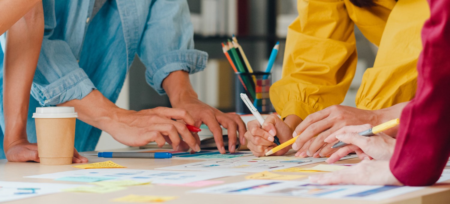 Creative design team brainstorming ideas and mapping project concepts using colorful sticky notes.